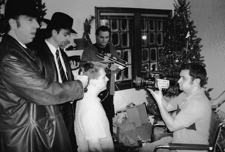 MERRY CHRISTMAS! cinematographer Kenny Gilbreath lines up a shot with actors (from left) John Dowers, Greg Trumbold, and Greg Wolf while James Schirmer looks on.